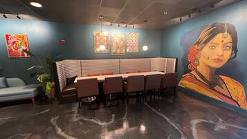 A restaurant with a booth seating area, a mural on the wall, and a ceiling with recessed lighting.