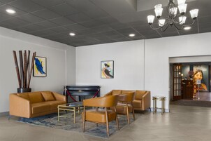 Una moderna hall con un divano, un tavolino da caffè e un lampadario.