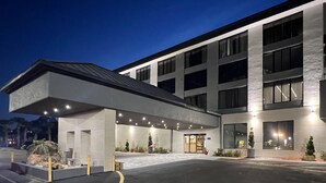 Un hôtel moderne doté d’une entrée couverte, de grandes fenêtres et d’un espace de stationnement.