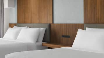 A hotel room with two beds, a wooden headboard, and a control panel.