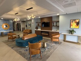 Una sala de estar moderna con chimenea, sofás de cuero y un televisor.