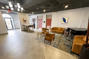 A spacious lobby with a bar area, seating, and a piano. - Best Western Premier Lakeland North (Lakeland)