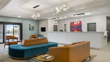 A modern lobby with seating, a reception desk, and artwork.