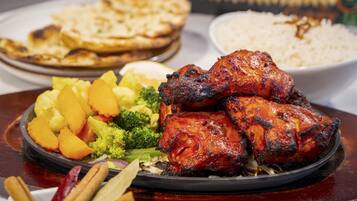 Un plato de pollo a la parrilla, verduras y arroz.