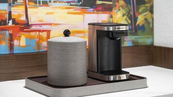Une machine à café et un récipient cylindrique sur un plateau.