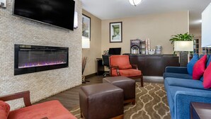 A modern living room with a fireplace, comfortable seating, and a flat-screen TV. - Comfort Inn Shelby (Shelby)