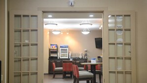 A hotel lobby with a reception area, a vending machine, and a seating area with chairs and tables. - Comfort Inn Shelby (Shelby)