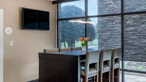 A modern kitchen with a large island, a flat-screen TV, and a stone wall. - Comfort Inn Shelby (Shelby)