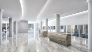 A spacious lobby with marble flooring, white columns, and a large wooden bench. - Hyatt Regency Rochester (Rochester)