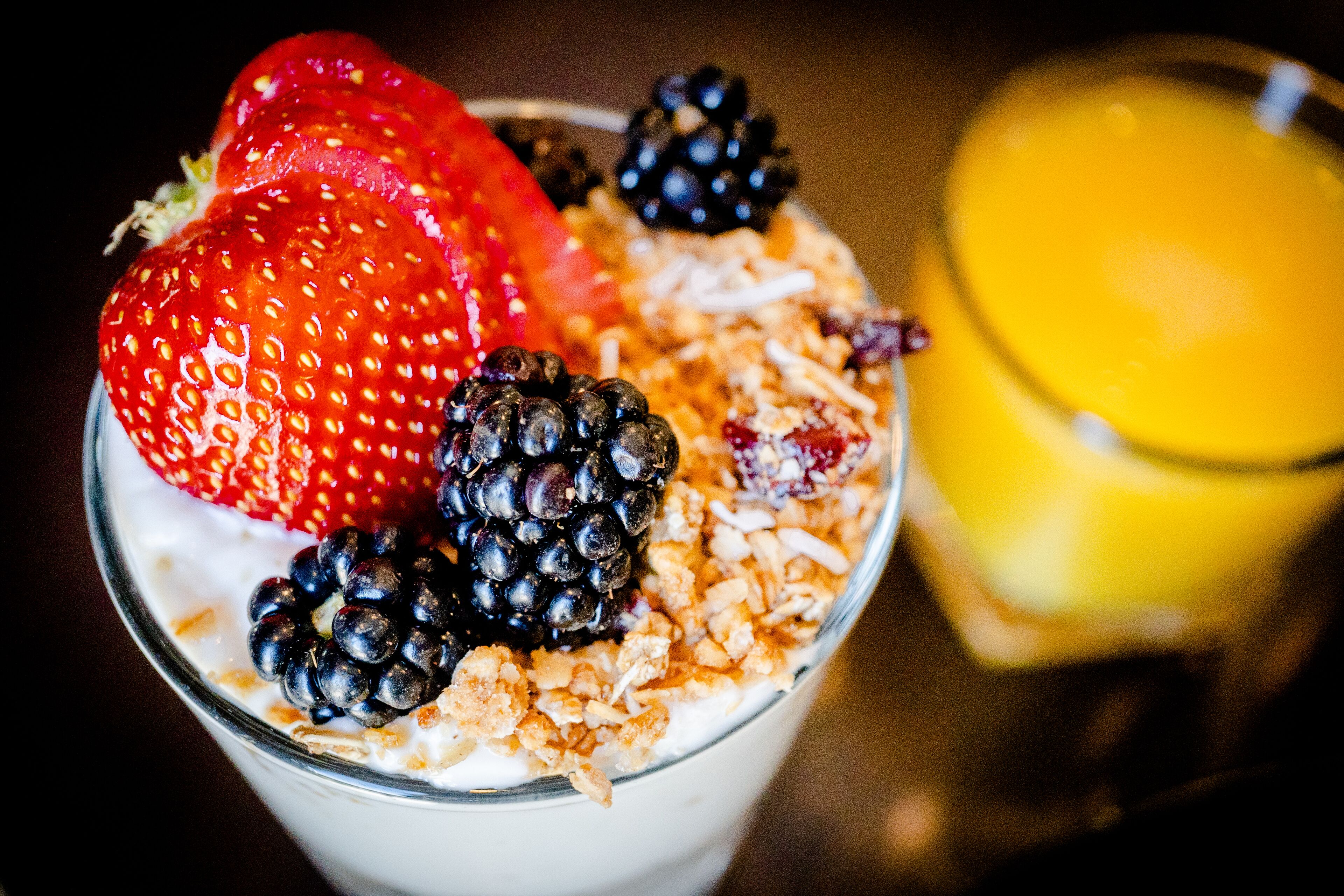 A dessert with strawberries, blackberries, and granola.