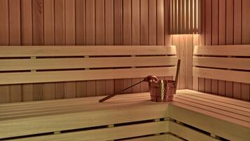 A wooden sauna bench with a copper bucket and a wooden stick.