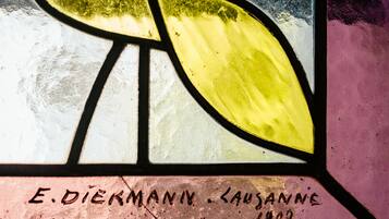 A stained glass window with inscriptions and a yellow leaf design.