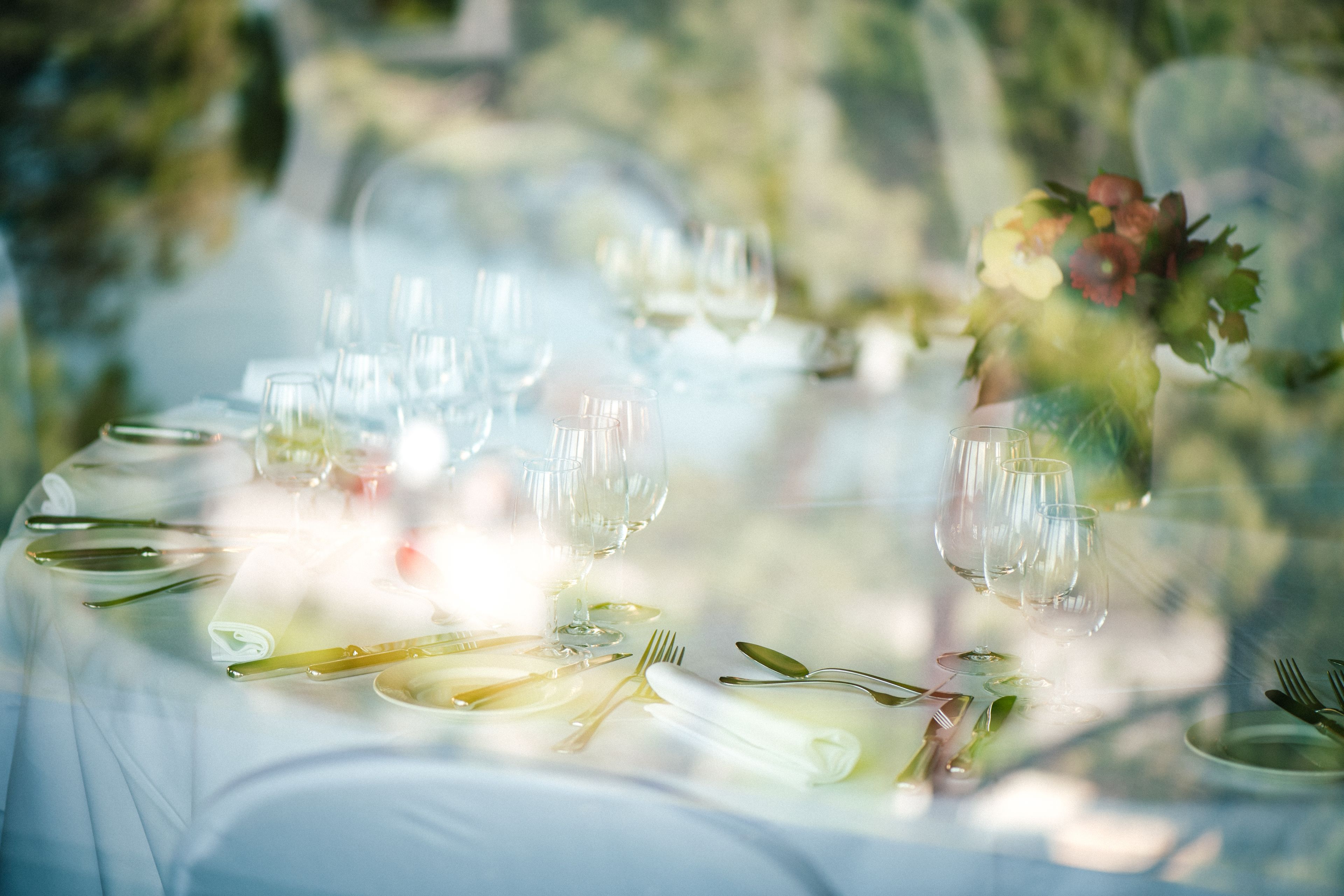 A table set with wine glasses, plates, and cutlery, suggesting a formal dining setting.