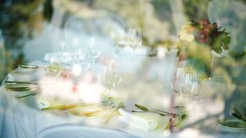 Una mesa servida con copas de vino, platos y cubiertos, evocando un ambiente de cena formal.