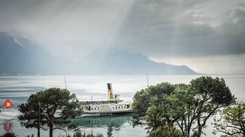Ein Boot mit dem Namen "La Suisse" auf einem See, im Hintergrund Berge.