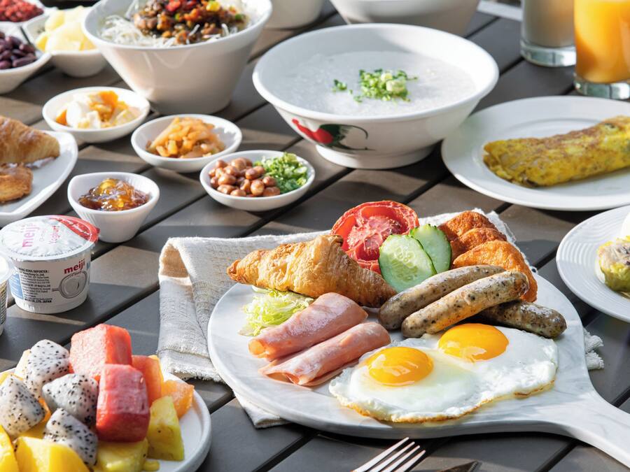 A breakfast spread with various dishes including eggs, sausages, and fruits.