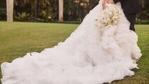 A couple in wedding attire on a grassy outdoor area with palm trees in the background. - Comfort Inn Oceanside Deerfield Beach (Deerfield Beach)