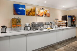 A hotel breakfast area with a coffee station, toaster, and refrigerator. - Comfort Inn Oceanside Deerfield Beach (Deerfield Beach)