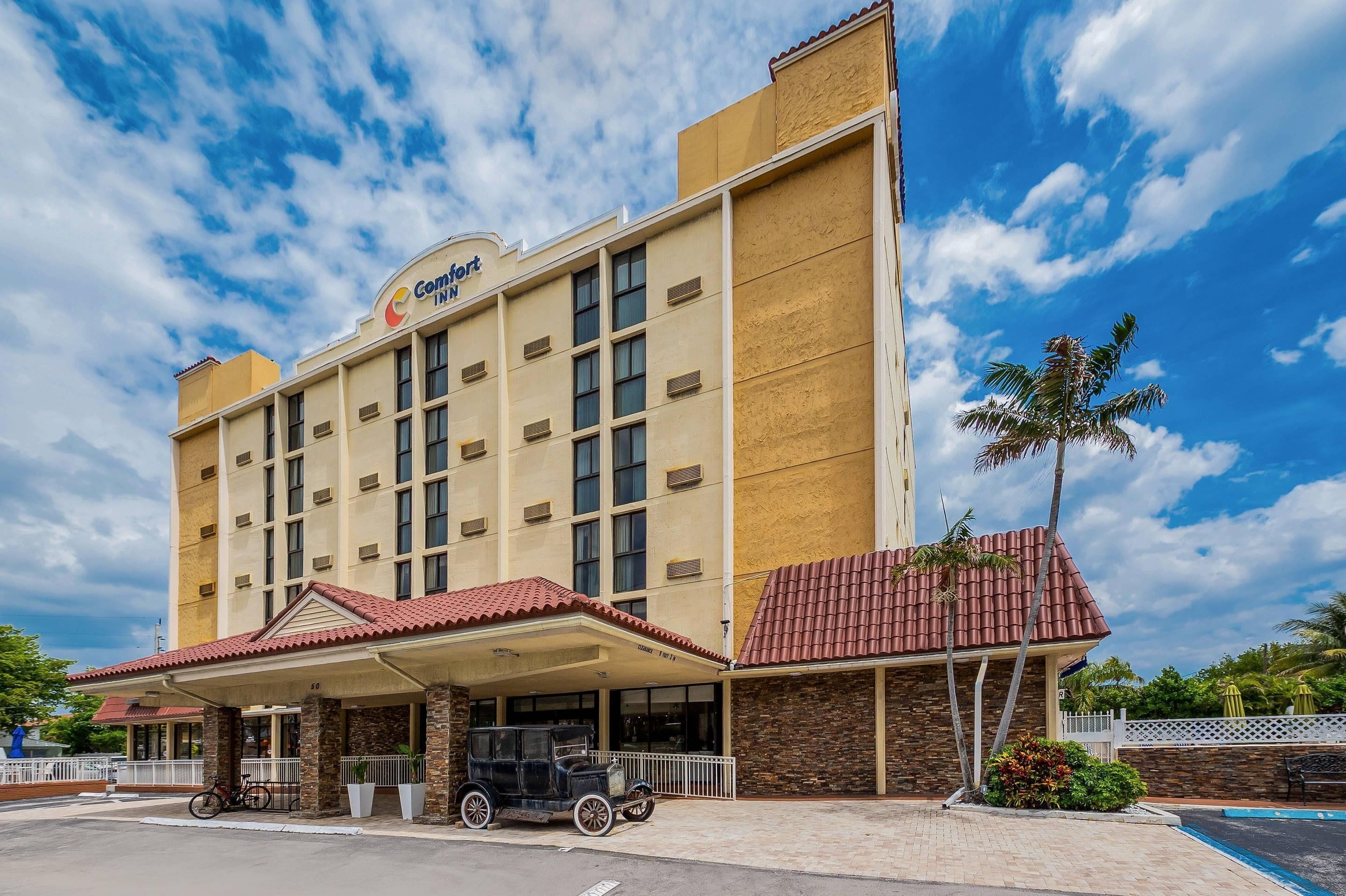 Um hotel com entrada coberta, área de piscina e design arquitetônico clássico.