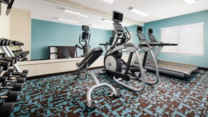 A gym with exercise equipment, a patterned carpet, and a window with blinds. - Fairfield Inn By Marriott Concord (Concord)
