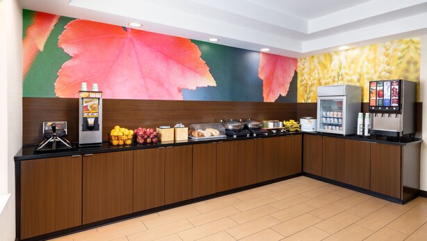 A modern breakfast bar with a variety of food options, a coffee machine, and a fruit display. - Fairfield Inn By Marriott Concord (Concord)