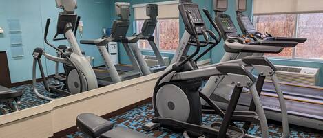 A gym with treadmills, an elliptical, and a bench.