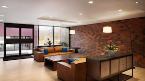 A modern lounge area with a sofa set, a coffee table, and a cabinet. - Hilton Boston/Dedham (Dedham)