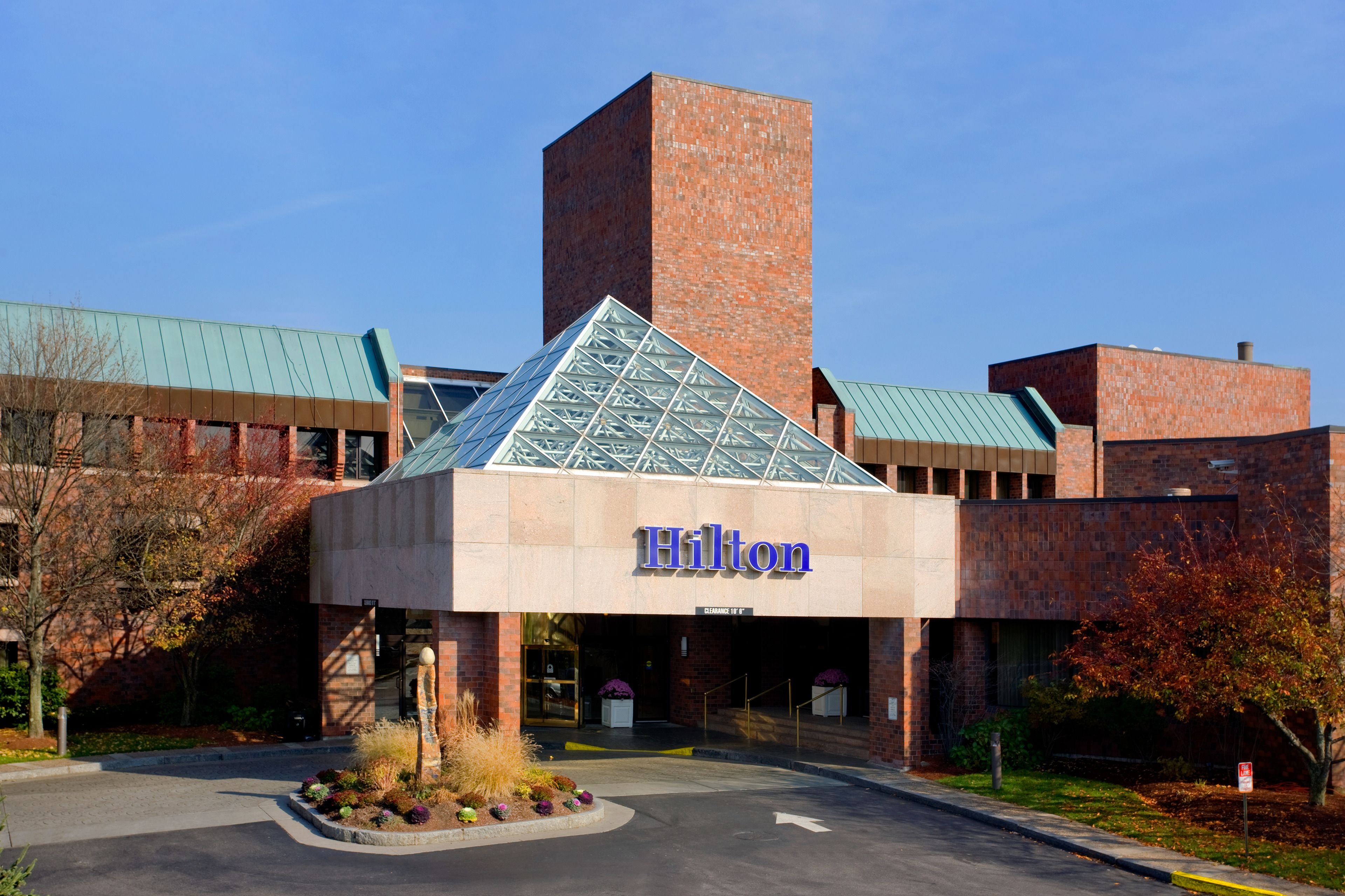 A Hilton hotel with a prominent brick tower and a glass pyramid entrance.