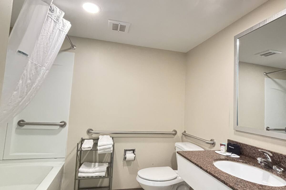 1 king bed mobility accessible room bathtub/shower w/ grab bars, non smoking | bathroom | hair dryer, towels