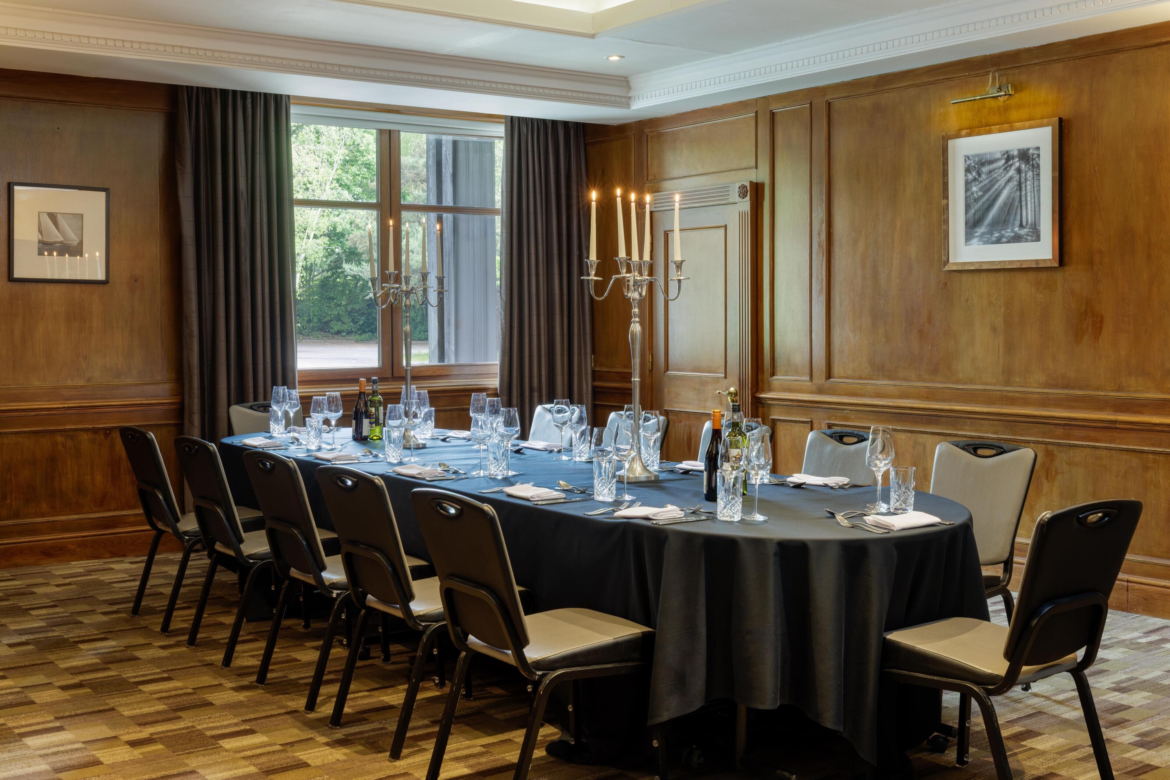 A conference room with a long table, chairs, and a candelabra.