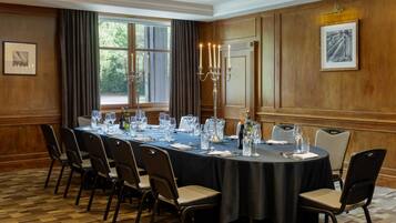 A conference room with a long table, chairs, and a candelabra.