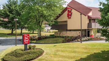 A Red Roof Inn with a two-story structure, a stone facade, and a red roof.