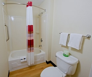 Ein Badezimmer mit Dusche, Toilette und Handtuchhalter.