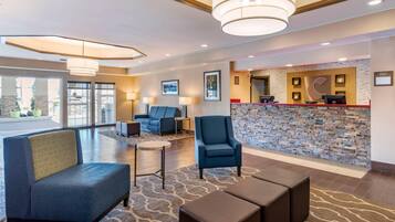 A lobby with seating, a reception desk, and a stone wall.