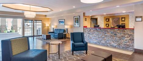 A lobby with seating, a reception desk, and a stone wall.