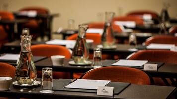 A conference room with tables set up for a meeting, each with nameplates, water bottles, and glasses.
