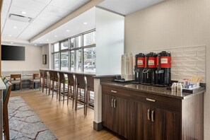 Una cocina moderna con barra, armarios de madera y espacio para café.