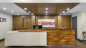 Una recepción con un diseño de panel de madera, una amplia pintura de paisaje urbano en la parte superior y un techo moderno con iluminación empotrada.