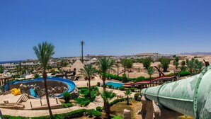 A resort with a large pool, palm trees, and a desert landscape in the background. - JAZ Fayrouz (Sharm El Sheikh)