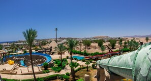 A resort with a large pool, palm trees, and a desert landscape in the background. - JAZ Fayrouz (Sharm El Sheikh)