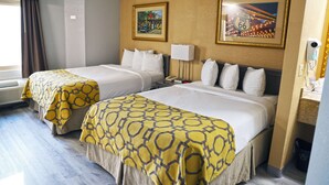 A hotel room with two beds, a window with curtains, a wall-mounted air conditioner, and two framed pictures. - Baymont by Wyndham Barstow Historic Route 66 (Barstow)