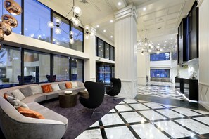 A modern lobby with a curved sofa, black chairs, and a checkered floor. - Exe Rey Don Jaime Hotel (Valencia)