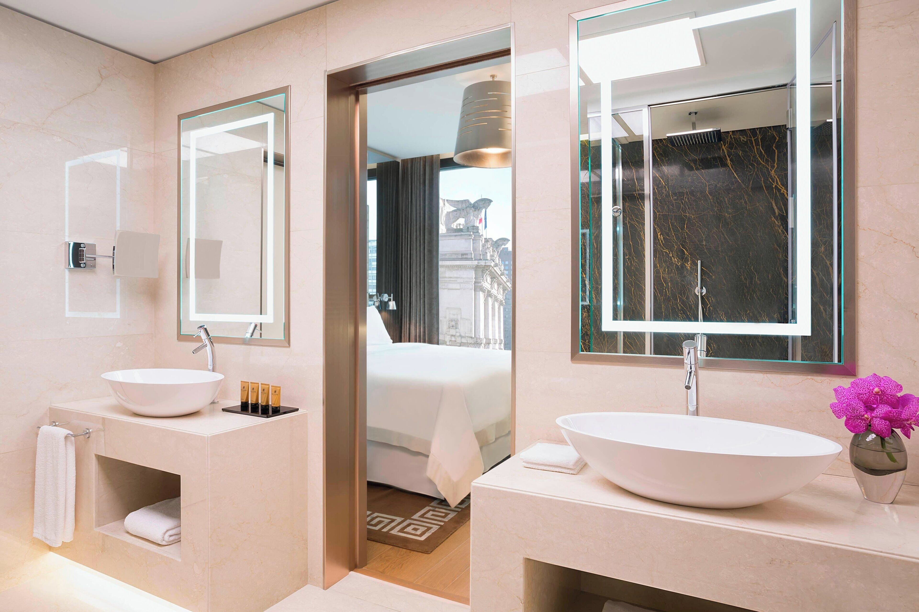 Ein modernes Badezimmer mit zwei Waschbecken, einem großen Spiegel und einer Duschkabine.