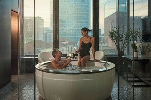 A modern indoor hot tub with a city view, a glass partition, and a potted plant. - Excelsior Hotel Gallia, a Luxury Collection Hotel, Milan (Milan)
