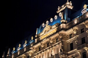 Un edificio imponente con dettagli architettonici elaborati e insegne illuminate.
