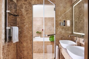 Un bagno moderno con box doccia in vetro, due lavandini e uno specchio grande.
