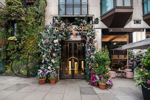 La entrada del hotel The Athenaeum, con un arco floral y plantas en macetas.