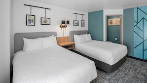 A hotel room with two beds, a nightstand, wall-mounted artwork, and a door leading to another room. - Sleep Inn near Washington State Line (Post Falls)