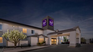 A Sleep Inn hotel with a clear entrance, a parking area, and a well-lit facade. - Sleep Inn near Washington State Line (Post Falls)