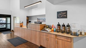 A reception area with a wooden counter, a laptop, a coffee machine, and a sign that says 'Dream Cup'. - Sleep Inn near Washington State Line (Post Falls)